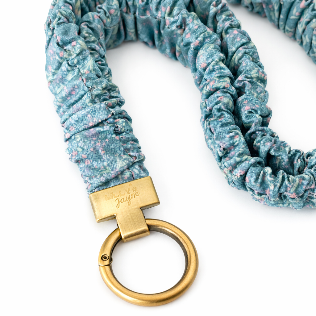 Blue floral-patterned keychain with a gold ring and clasp on a white background
