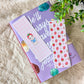 Purple notebook with a white bookmark featuring a snowman and strawberry pattern on a fluffy surface.